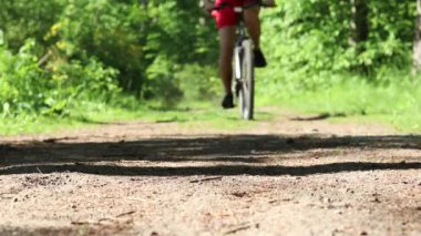 Bir adam ormanda bisiklet sürüyor..