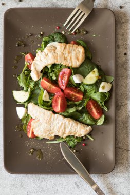 Ispanak yapraklı salata, roka, kiraz domatesleri, mozzarella ve et parçaları. Diyet yemek. Ev yapımı..