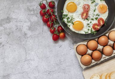 Kızartma tavasında yumurta. Beton gri arka planda. Tabakta.