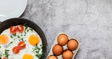 Kızartma tavasında yumurta. Beton gri arka planda. Tabakta.