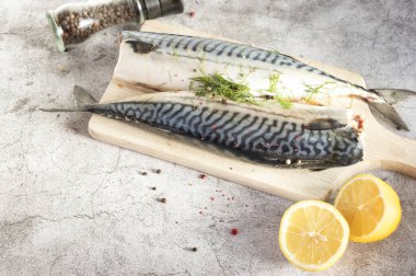 Taze çiğ uskumru balığı. Gri bir arka planda. Limonlu çiğ balık ve sos.