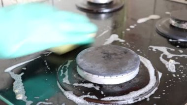 Mutfak temizliği. Yeşil koruyucu lastik eldivenli kadın mutfak mobilyalarını temizliyor.