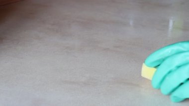 Mutfak temizliği. Yeşil koruyucu lastik eldivenli kadın mutfak mobilyalarını temizliyor.