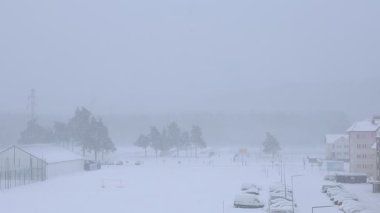 Pencereden dışarıda kar yağdığını görebiliyorsun. kış