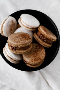 Parlak arka planda makaronlar, renkli Fransız kurabiyeleri. Kurabiyeler. Vanilyalı ve çikolatalı tatlı. Sağlıklı vejetaryen şeker yok. 8 Mart - Uluslararası Kadınlar Günü
