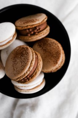 Parlak arka planda makaronlar, renkli Fransız kurabiyeleri. Kurabiyeler. Vanilyalı ve çikolatalı tatlı. Sağlıklı vejetaryen şeker yok. 8 Mart - Uluslararası Kadınlar Günü