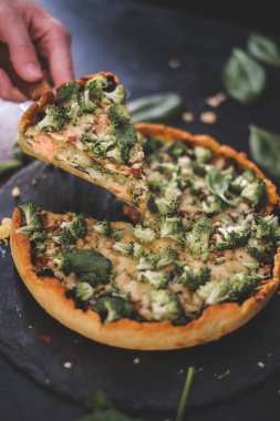 Millet kiş, ıspanak, somon, brokoli ve ricotta ile koyu ahşap masa. Ev yapımı vejetaryen keki. Uzayı metin için kopyala. Yumuşak peynirli taze turta. Sağlıklı yiyecekler. Fransız mutfağı.