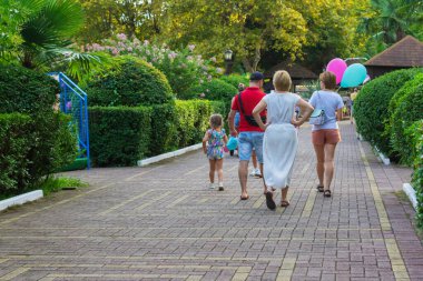 İnsanlar yaz parkında balonlarla yürüyorlar..