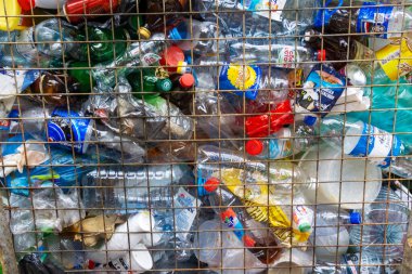 Parmaklıkların arkasında boş plastik şişeler .