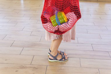 Plaj eşyaları kırmızı bir çantada. Bir kadının güzel bacakları..