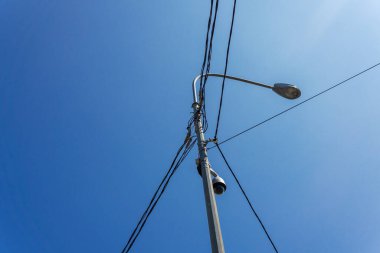  Sokak lambası ve elektrik kabloları mavi gökyüzü arka planına karşı.