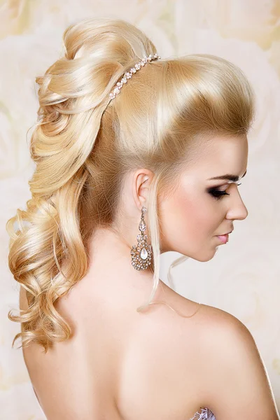 Retrato de beleza de uma bela loira com um cabelo festivo e maquiagem brilhante . — Fotografia de Stock
