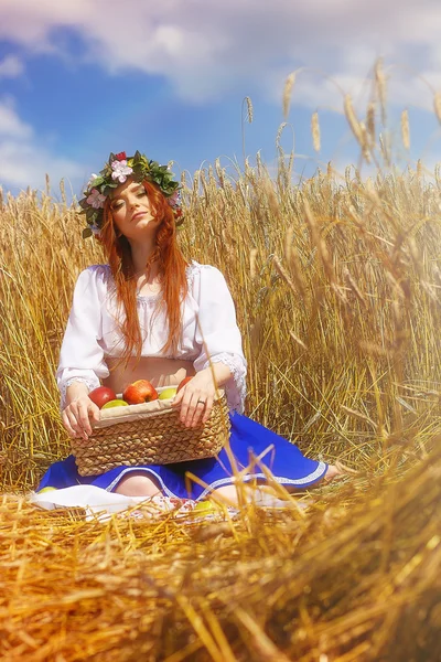 ライ麦畑のりんごで赤毛の女の子 ストック画像