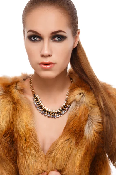 Portrait of a glamorous girl in a fur coat on a background of snowflakes — Stock Photo, Image