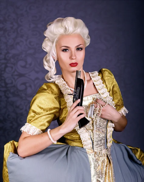 Όμορφη βασίλισσα αγέρωχος στο Βασιλικό ένδυσης με μαργαριτάρια και με ένα πυροβόλο όπλο — Φωτογραφία Αρχείου