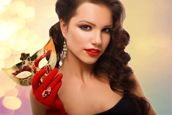 美容モデルの女性パーティーで赤い手袋とシックなジュエリーでベネチアの仮装カーニバル マスクの着用 ストック画像