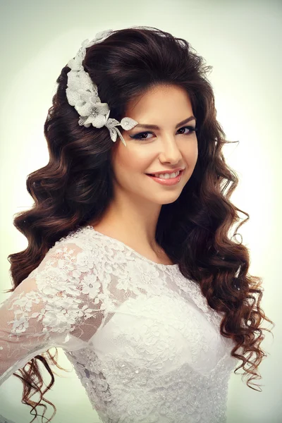 Portrait of a beautiful young brunette girl in white lace wedding dress  and luxury accessories isolated on white — Stock Photo, Image