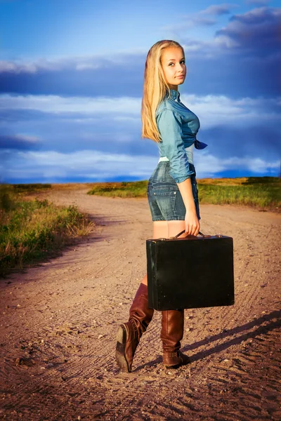 Dziewczyna w pośpiechu z walizką na drodze — Zdjęcie stockowe