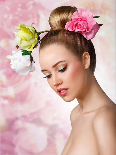 Mode schoonheid Model meisje met Rose bloemen haar. Make up en kapsel. Kapsel. Naakt make-up. Boeket van mooie bloemen op lady's hoofd. — Stockfoto