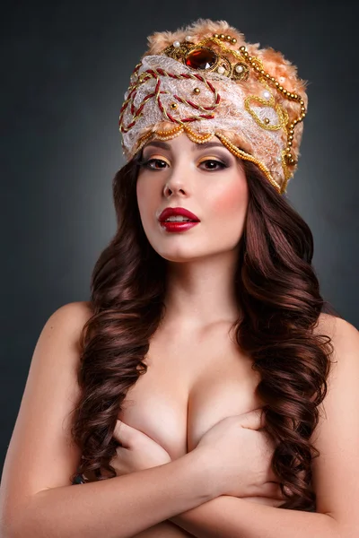 Fashion glamor girl in a beautiful headdress covers breasts with her hands.sexy queen — Stock Photo, Image