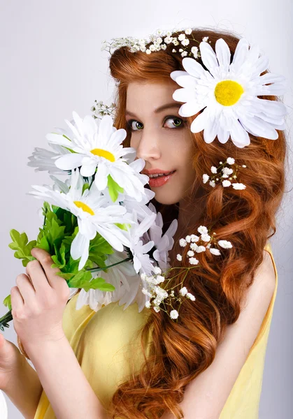 Dívka s sedmikrásky v jejích vlasech drží kytici sedmikrásky — Stock fotografie