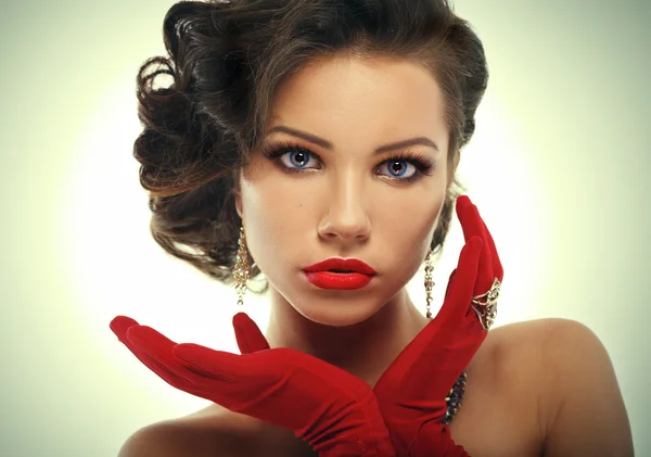 Kırmızı eldiven yüz yakınındaki elele Glamour kız. Vintage tarzı gizemli kadın kırmızı eldivenler.