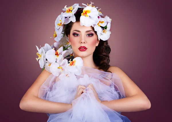 Girl with orchids flower in her hair. Professional Make-up.Makeup. Fashion Art.Hairstyle with flowers. Fantasy girl portrait . — Stock Photo, Image