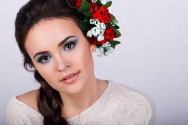 Uzun siyah kıvrım ve saçında çiçekler ile kız. Güzel esmer kız portresi stüdyo