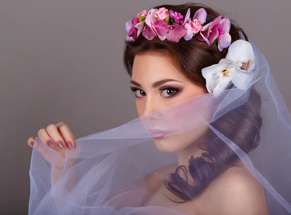 Dívka pokrývá veil.girl obličej s orchideje květiny ve vlasech. Profesionální Make-up.Makeup. Módní umění. — Stock fotografie