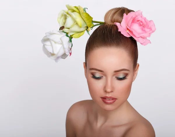 Moda beleza modelo menina com flores de rosa no cabelo. Maquiagem e estilo de cabelo. Penteado . — Fotografia de Stock