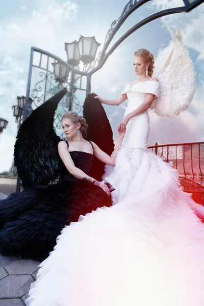 Two angels.  black angel standing over white angel — Stock Photo, Image
