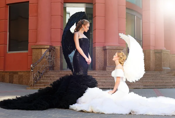 Dois anjos. preto anjo de pé sobre branco anjo — Fotografia de Stock