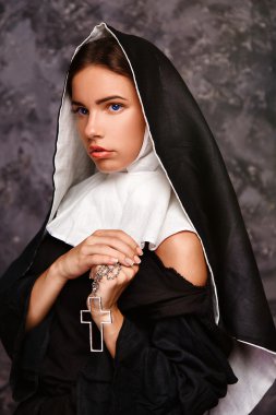 bir çapraz tutarak Rahibe