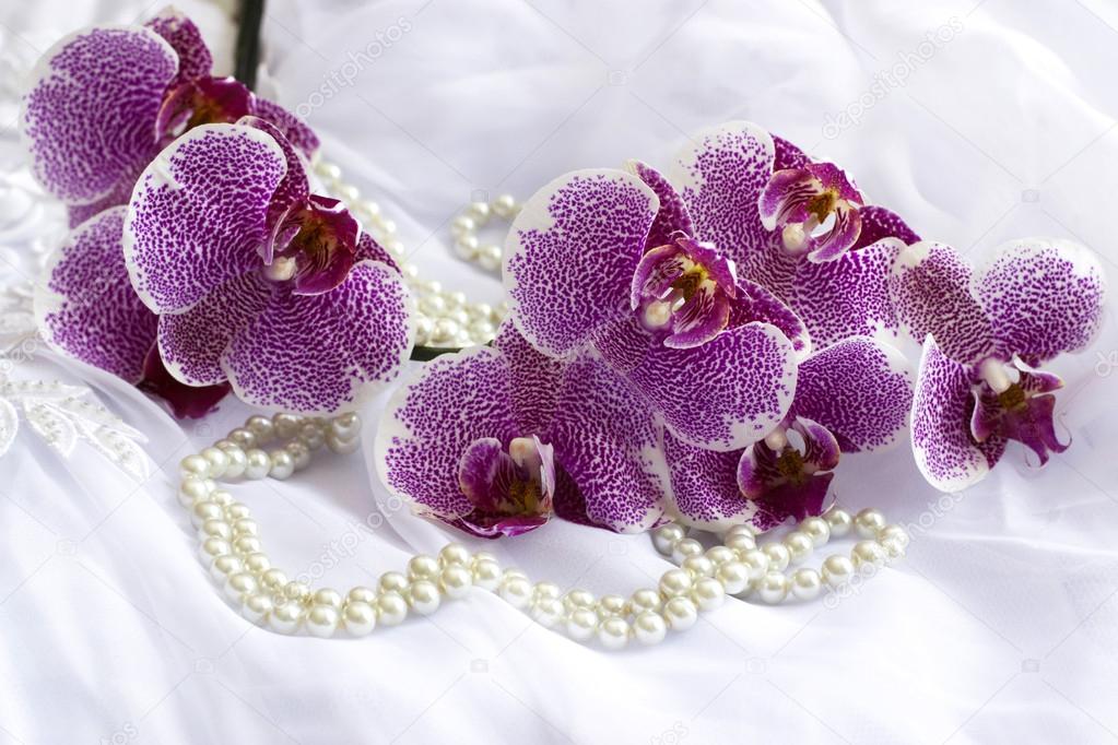 orchid flowers and pearls on a wedding dress.