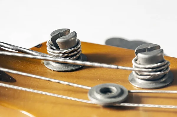 베이스 기타의 주축에 기둥의 조율하는 악기들과 기계들 — 스톡 사진