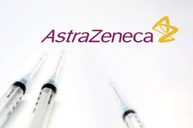 Cambridge, İngiltere, İngiltere, 10 Şubat 2021: AstraZeneca logosunun yanındaki üç şırınga beyaz arka planda izole edildi. Sağlık ve önleme. AstraZeneca Covid-19 Aşısı