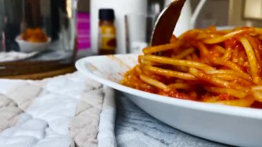 Çelik çatal kullanarak domates soslu spagetti sarmak. İtalyan yemeği. Masa takımıyla öğle yemeği.