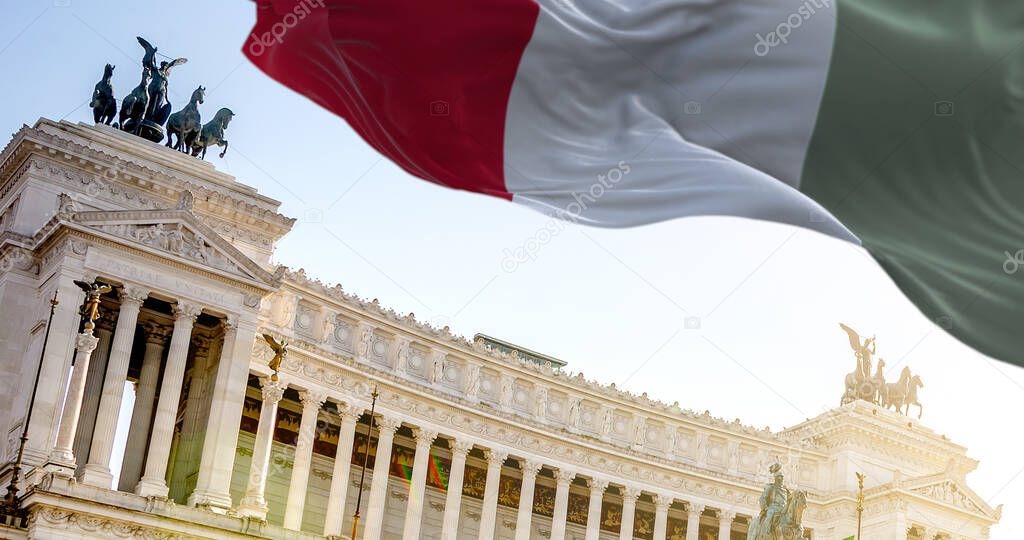 The Italian flag waving in the wind with Vittoriano in Rome in the background. Travel and tourist destinations. Art and architecture. World famous Italian historical monument