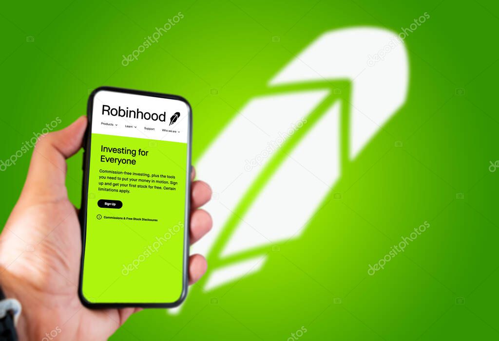 Menlo Park, CA, USA, April 2021: hand holds a smartphone with the Robinhood logo on the screen. Green background with blurred logo. Robinhood is a financial american services company