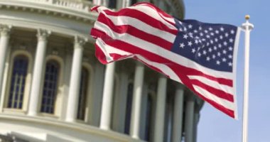 Başkent binasının önünde dalgalanan Amerika Birleşik Devletleri bayrağı arka planda bulanıklaştı. Washington D.C. 'deki Capitol Hill' de Birleşik Devletler Federal Kongresi Demokrasi ve Özgürlük..