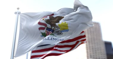 Illinois eyaletinin bayrağı rüzgarda dalgalanırken arka planda Amerikan bayrağı belirsizleşti. Demokrasi ve bağımsızlık. Amerika Orta Batı Eyaleti.