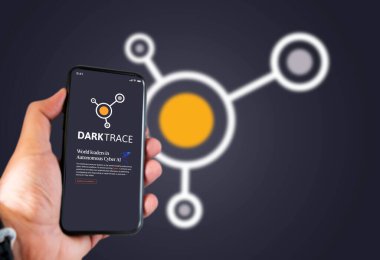 Cambridge, İngiltere, Mayıs 2021: Ekranda Darktrace şirketinin logosu olan bir telefonu tutan bir el. Darktrace, siber savunma konusunda uzman bir yapay zeka şirketi.