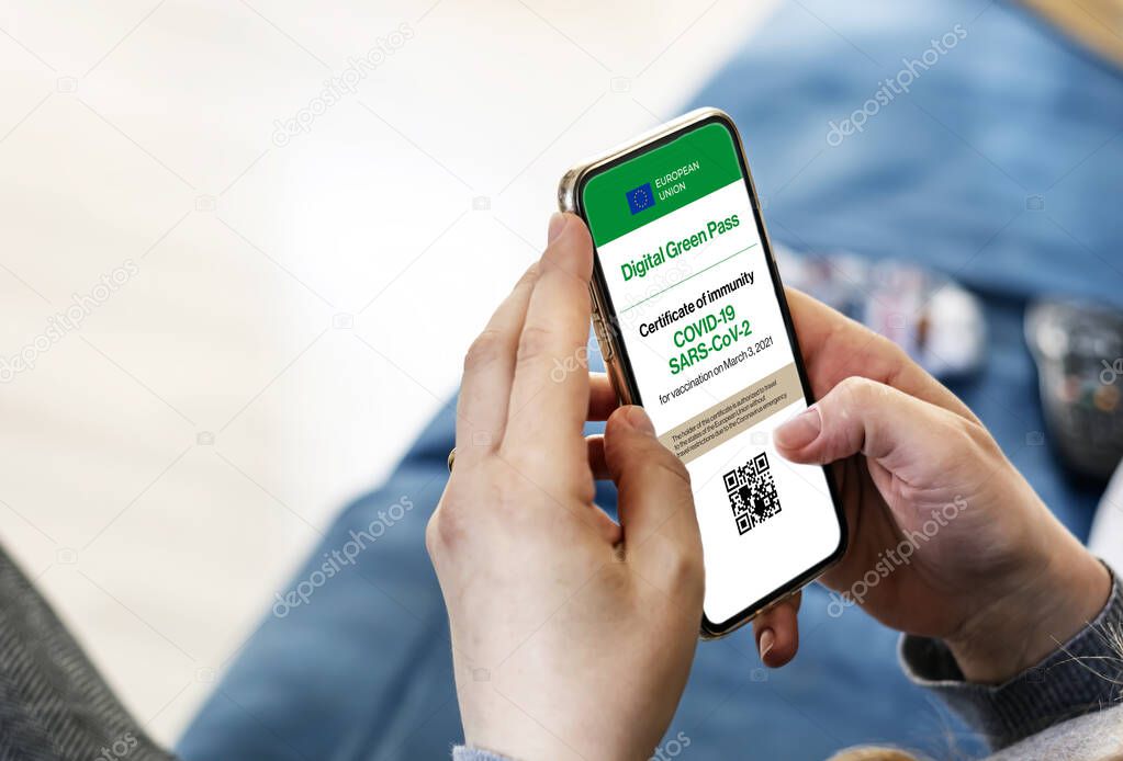 woman holding a smartphone with Covid-19 digital certificate on the screen. Digital Green Pass allows traveling within the European Union without the travel restrictions due to the Covid-19 pandemic