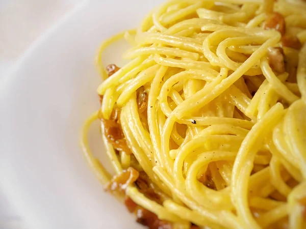 調理されたスパゲティをカルボナーラソースで閉じます イタリア料理の伝統的なレシピ 黄色のカルボナーラの卵の黄身ソースとパスタを調理 — ストック写真