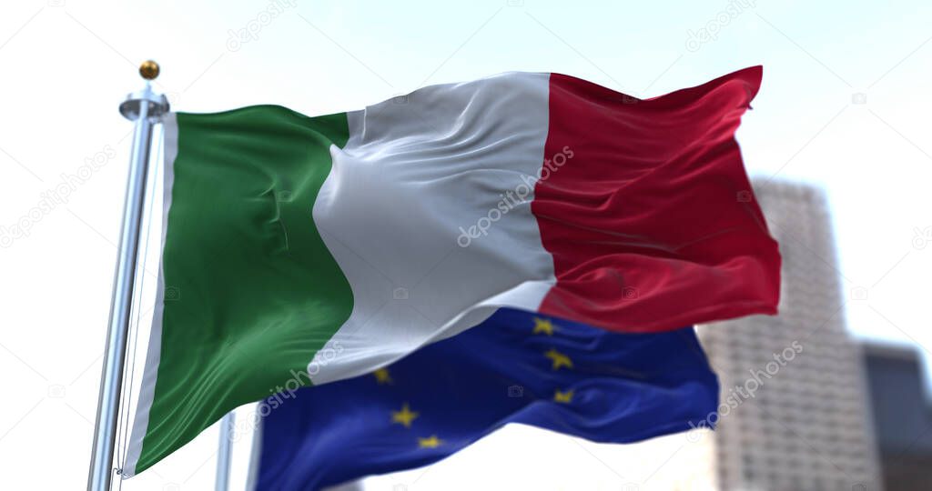 The national flag of Italy waving in the wind together with the European Union flag blurred in the background. Politics and finance. Italy is a member state of the European Union