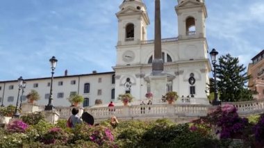 Roma 'daki İspanyol Merdivenleri' nin tepesindeki Trinit dei Monti kilisesinin cephesinde açelyalar çiçek açıyor. Seyahat ve turizm. Ünlü bir yer.
