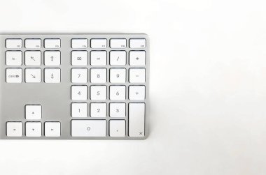 Beyaz masadaki modern beyaz bilgisayar klavyesinin ayrıntıları. Bilgisayar donanım cihazı. Teknoloji ve İnternet