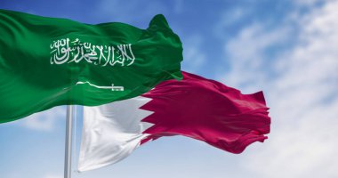 Suudi Arabistan ve Katar ulusal bayrakları açık bir günde rüzgarda sallanıyor. Tarihsel açıdan gergin durumdaki Körfez komşuları, rakipleri 2021 'deki uzlaşma sonrasında ihtiyatlı ortaklar haline geldi. 3d illüstrasyon oluşturucu.
