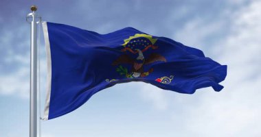 Kuzey Dakota eyaleti bayrağı açık havada rüzgarda sallanıyor. Mavi ve armalı. Kartal Kuzey Dakota parşömeninin üstünde. Kusursuz 3 boyutlu animasyon. Yavaş çekim döngüsü. Seçici odak