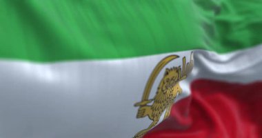 İran Pahlavi dönemi Aslan ve Güneş bayrağının rüzgarda dalgalandığı yakın plan çekimleri. 1979 öncesi İran Pahlavi dönemi. Kusursuz 3 boyutlu animasyon. Yavaş çekim döngüsü. Seçici odak